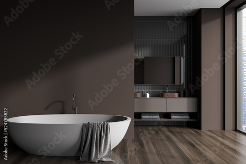 Dark bathroom interior with bathtub and washbasin near panoramic window. Mockup