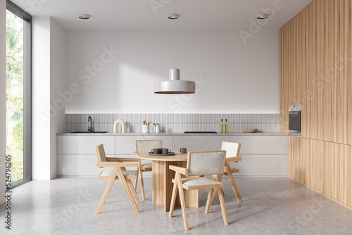 Stylish kitchen interior with eating table and seats, panoramic window