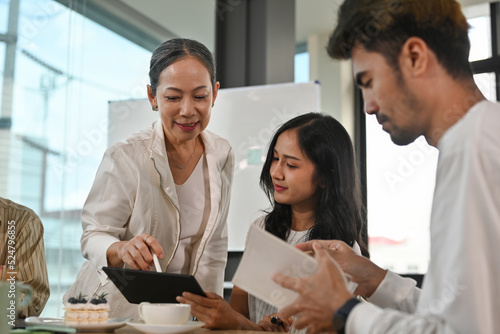 Wallpaper Mural Close up of Senior old age businesswoman leader discussing, brainstorming, sharing ideas and solutions, negotiating on project with business team in office meeting room together. Torontodigital.ca