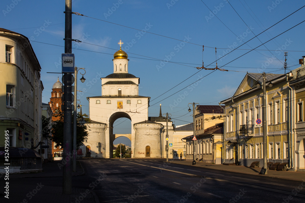 Vladimir, Russia - August, 16, 2022: facade of the old white stone golden Gate in the historical center of the city on a sunny summer day