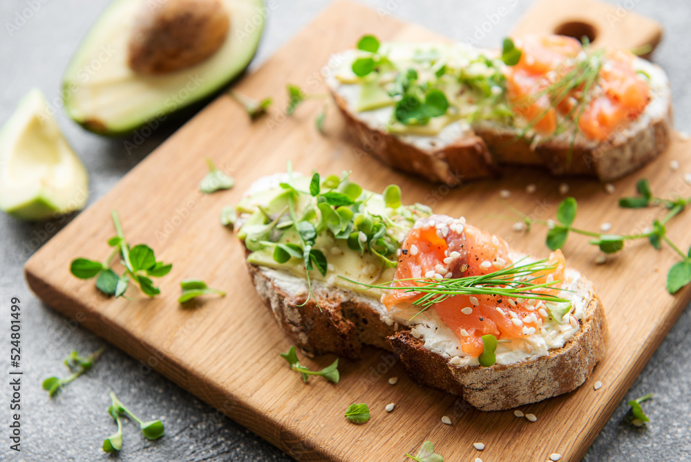 Sandwiches with salted salmon,  avocado and microgreens.