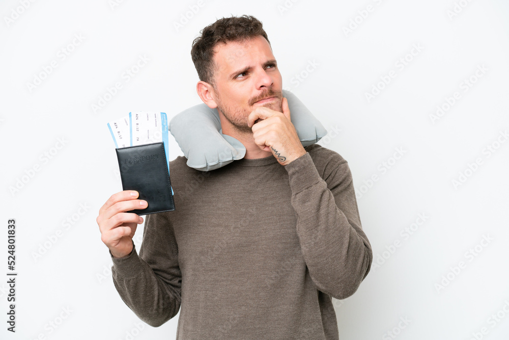 Young caucasian man holding a passport isolated on white background having doubts Young caucasian man holding a passport isolated on white background having doubts