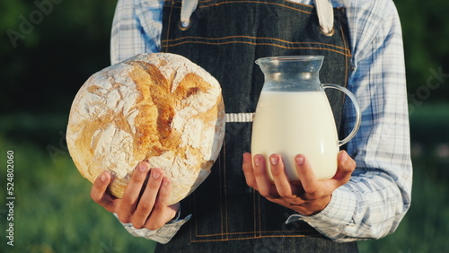A farmer holds a jug of milk and a loba loaf. Healthy Organic Food photo
