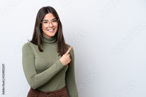 Young Brazilian woman isolated on white background pointing to the side to present a product © luismolinero