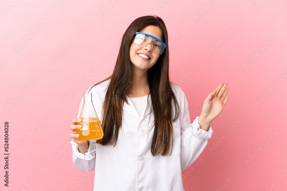 Young scientific girl over isolated pink background saluting with hand with happy expression Young scientific girl over isolated pink background saluting with hand with happy expression