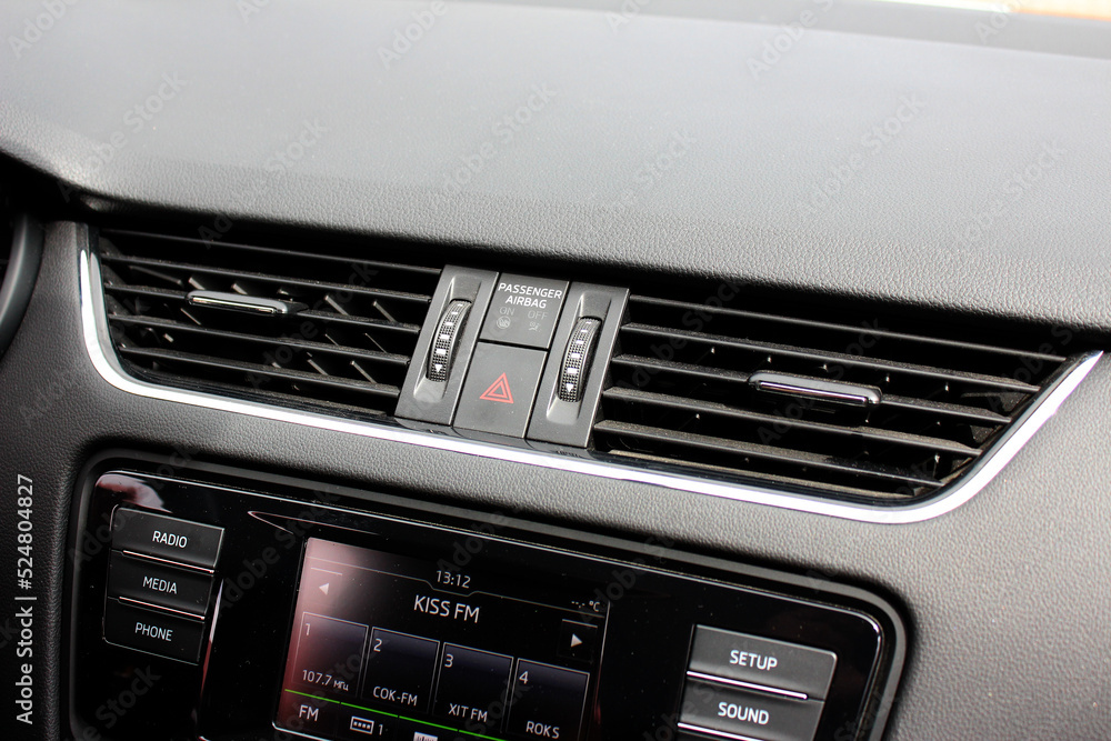 Car air vents close-up grille and warning light switch in a car. Air ventilation grille with power regulator. Dashboard Modern Car air conditioner.