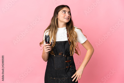 Young hairdresser woman isolated on pink background thinking an idea while looking up