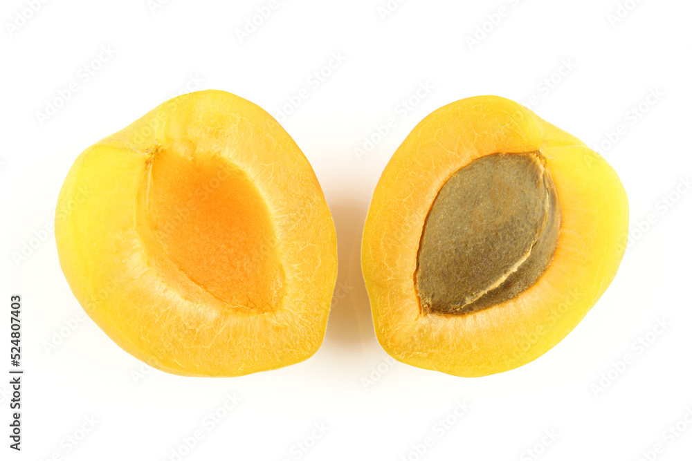 Two halves of apricot fruit with core seed isolated on white background