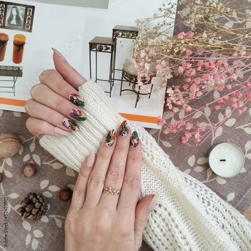 close-up of female hands with autumn manicure and accessories on the table