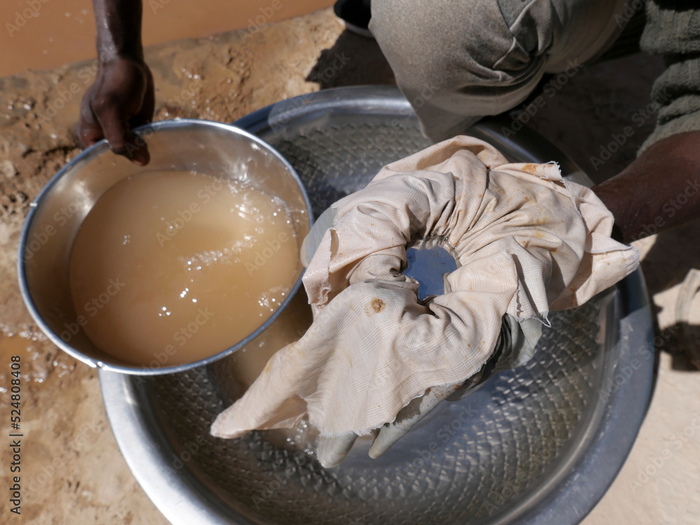 Fototapeta premium Artisanal miner using mercury to attract gold from ore mixed with water. Mercury is a toxic product that should be handled carefully and that can have a significant impact on health and environment.