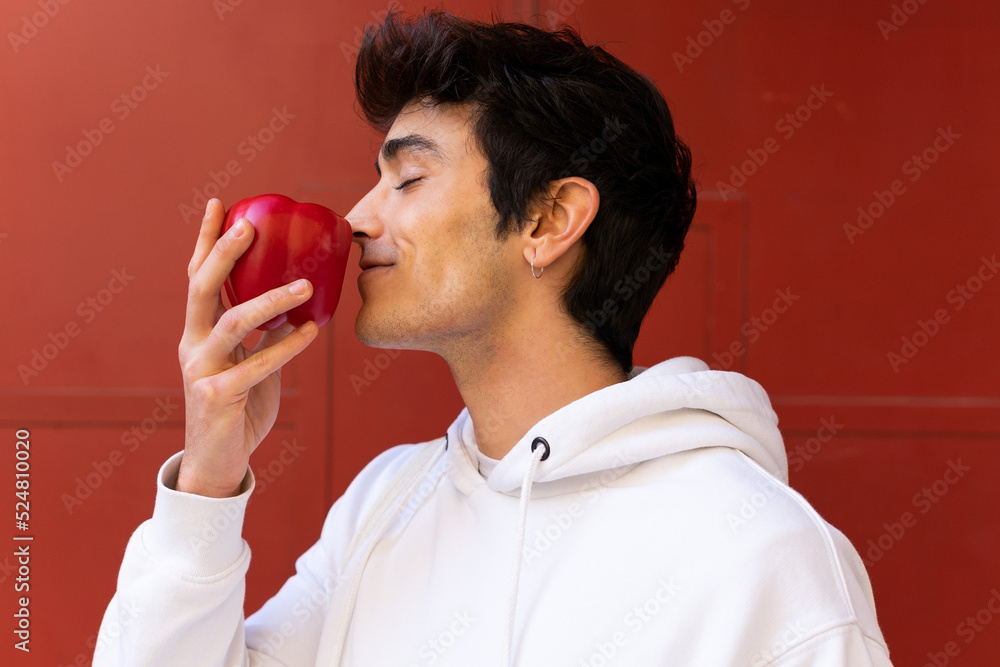 Man smelling aromatic red pepper in city