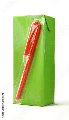 Green carton juice box with red plastic straw attached isolated on white background photo