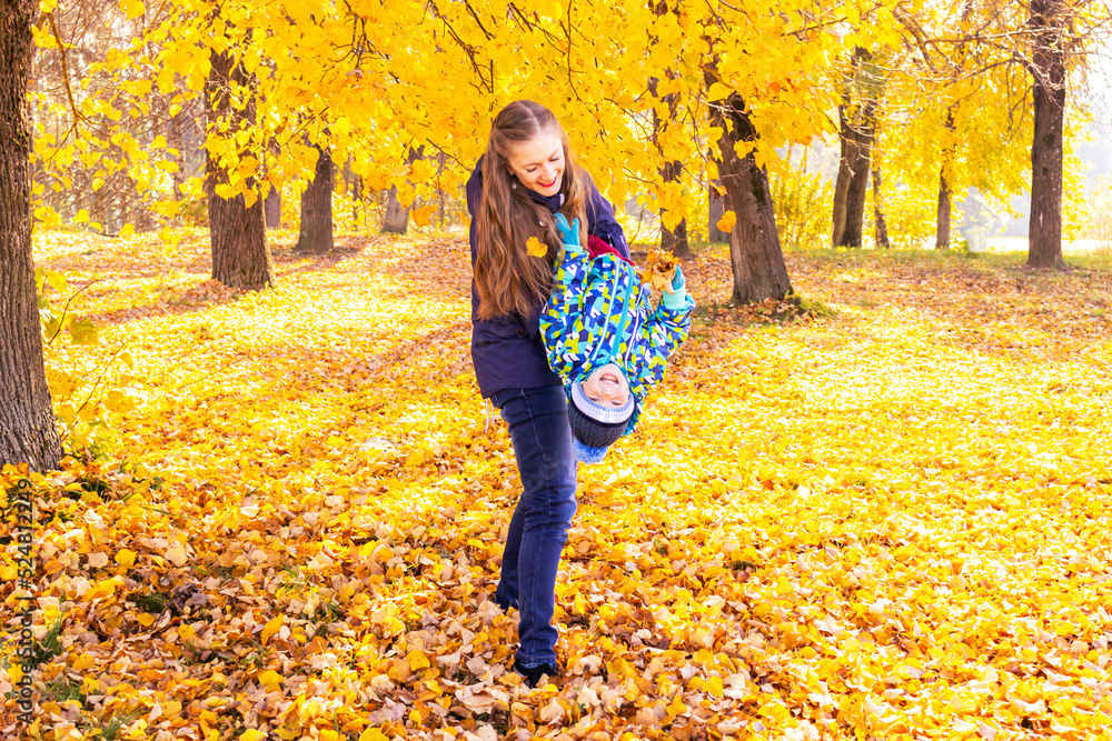 mother holding son playing and have fun in autumn leaves mother holding son playing and have fun in autumn leaves
