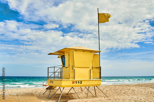 rescue tower on sandy shore against ocean under cloudy sky photo