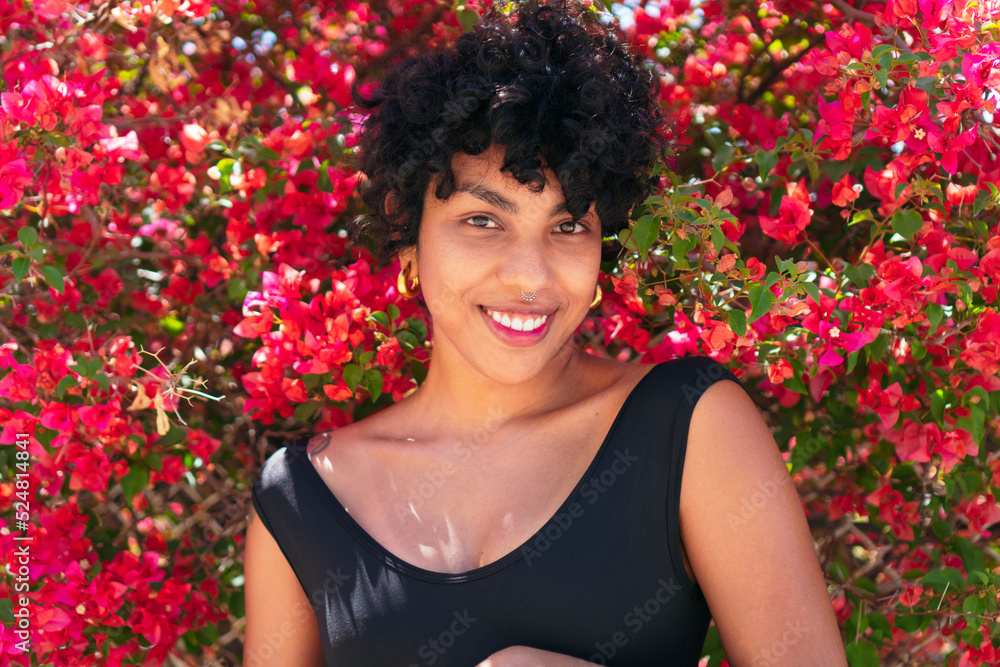 Cheerful black woman against blooming bush Cheerful black woman against blooming bush
