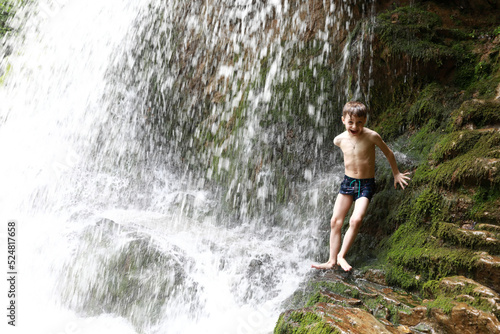 Child under waterfall Shum on Rufabgo stream