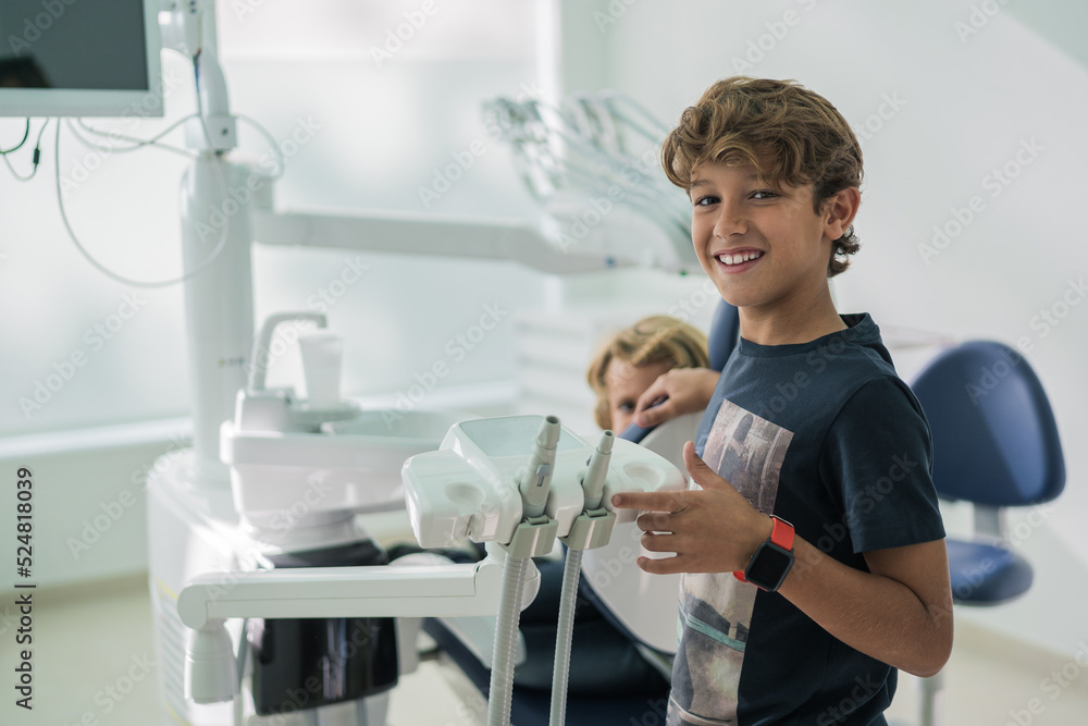 Cheerful boy supporting brother in dental clinic Cheerful boy supporting brother in dental clinic