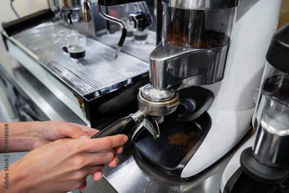 Crop barista preparing coffee in machine Crop barista preparing coffee in machine