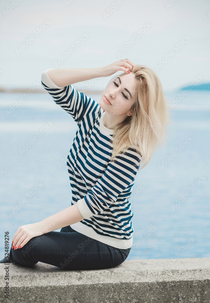 Girl in striped sweeter, fashionable details on a model, classical trend in wardrobe