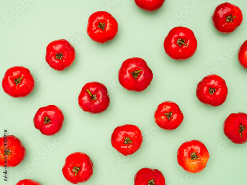 Obraz na plátne Ripe red acerola cherries isolated on a light green background