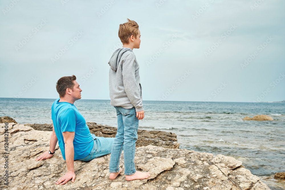 Happy family, father and son bonding, sitting on stone by the sea looking at view enjoying summer vacation. Togetherness Friendly concept
Happy family, father and son bonding, sitting on stone by the sea looking at view enjoying summer vacation. Togetherness Friendly concept