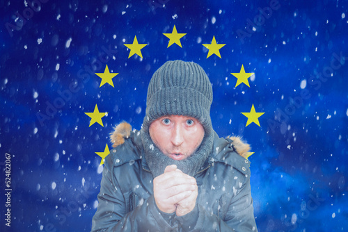 A Middle age man in the background of the EU.A citizen of Europe freezes in front due to the big price of gas.Huge price of natural gas for home heating.Copy space.