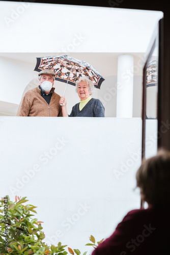 Senior couple communicating with neighbor during quarantine photo