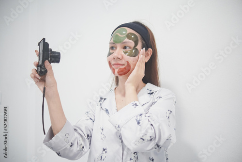 Asian woman beauty vlogger or blogger live broadcasting cosmetic makeup tutorial viral video clip by camera sharing on social media. Business online influencer on social media concept.