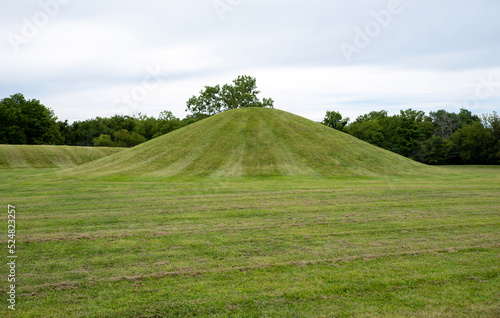 Ancient Native American burial mounds in Mound City Ohio, USA Hopewell Culture prehistoric Earthworks burial mounds in Mound City park Ohio. Circular grass-covered mound in foreground photo