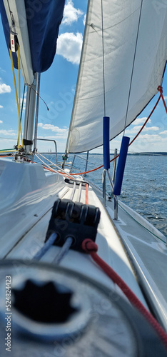 white sail on a sailboat in the background of blue lake and sky
