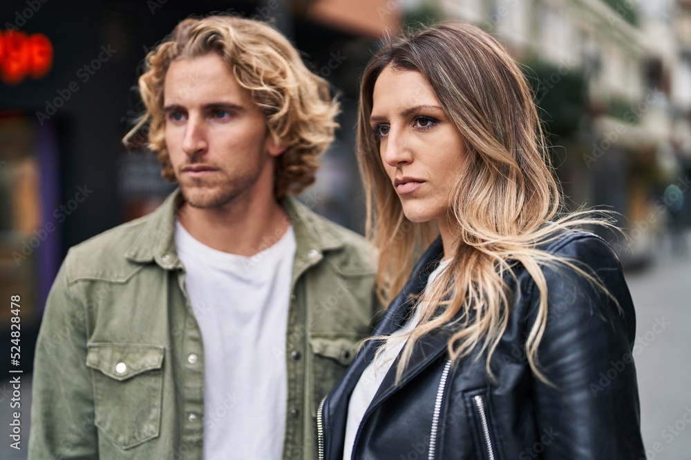 Man and woman couple standing together with relaxed expression at street Man and woman couple standing together with relaxed expression at street