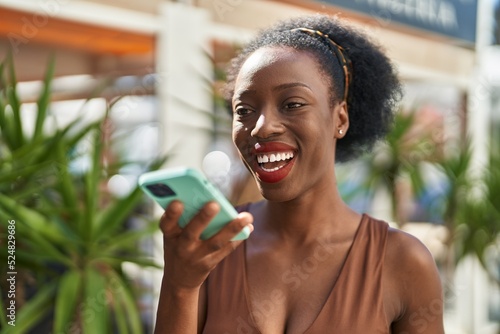 African american woman smiling confident talking on the smartphone at street