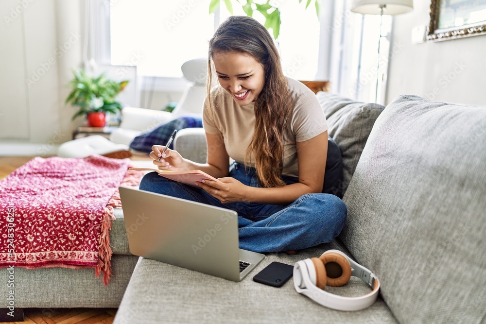 Young hispanic girl having online class sitting on the sofa at home. Young hispanic girl having online class sitting on the sofa at home.