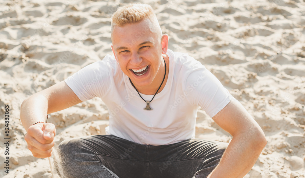 Smiling young handsome stylish student, blonde guy, lifestyle of teen- youth life. Portrait of young man