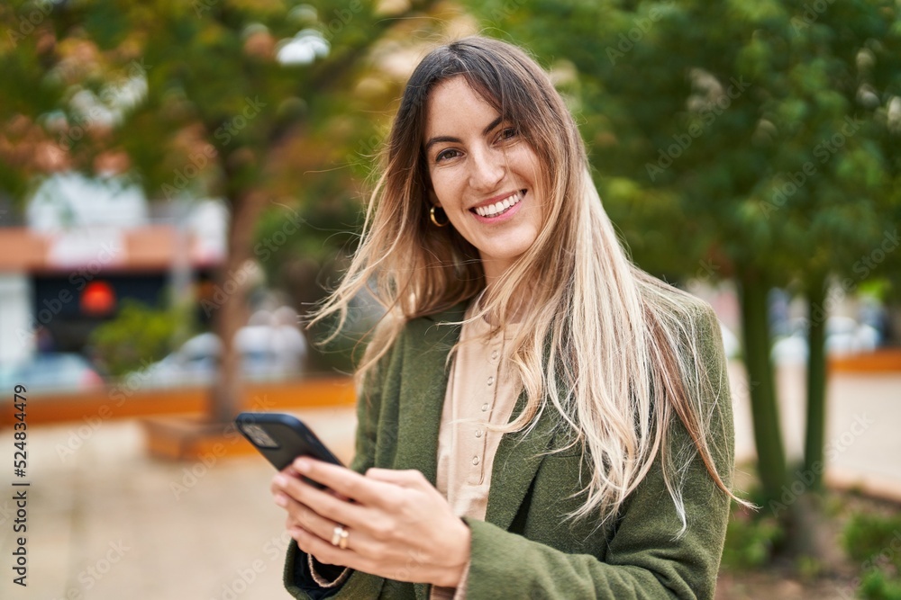 Young woman smiling confident using smartphone at park Young woman smiling confident using smartphone at park
