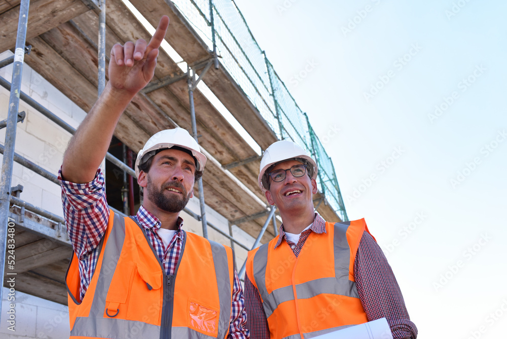 teamwork on the construction site - site manager and architect on site during the construction of a house teamwork on the construction site - site manager and architect on site during the construction of a house