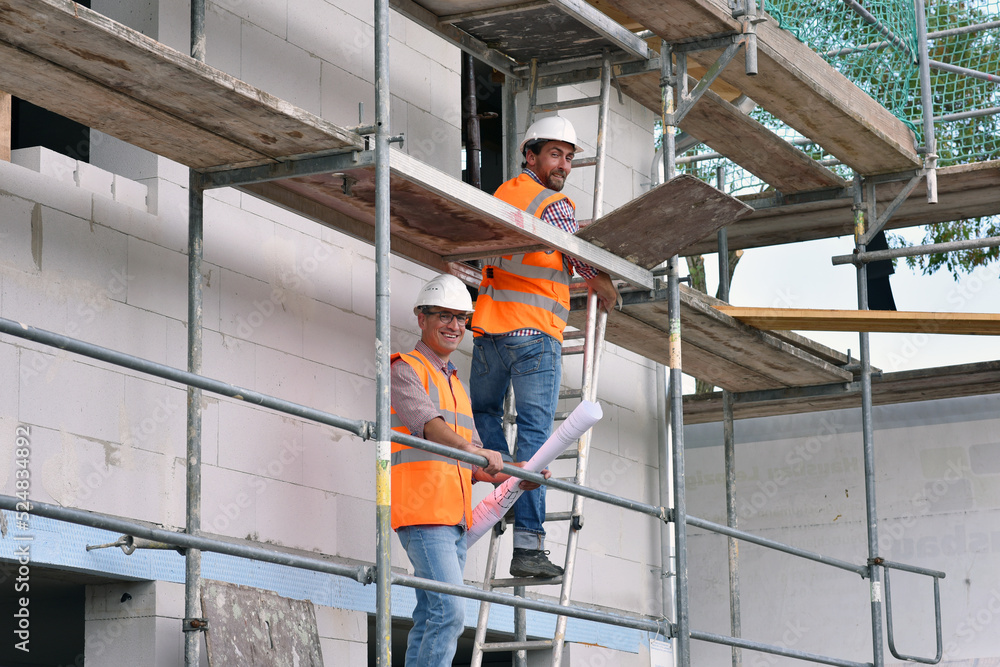 construction manager and architect on site during the construction of a house - planning and control on site - teamwork construction manager and architect on site during the construction of a house - planning and control on site - teamwork