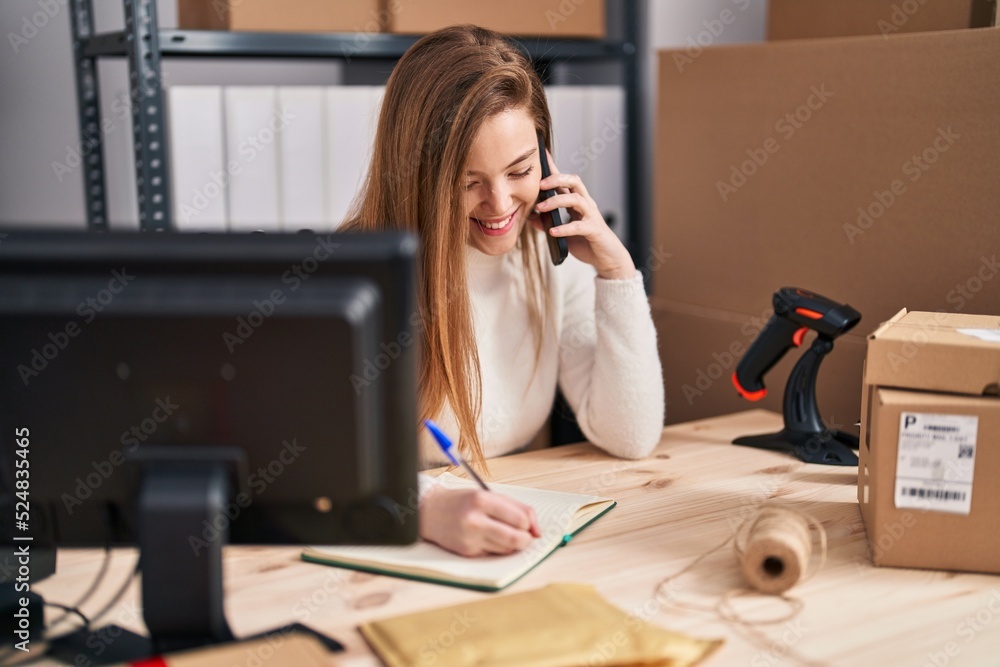 Young blonde woman ecommerce business worker talking on the smarpthone at office Young blonde woman ecommerce business worker talking on the smarpthone at office
