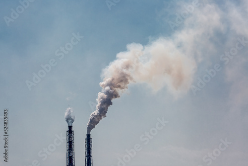 Working factory. Smoke from the factory chimney. Ecological pollution. Air emissions polluting the city. Industrial waste is hazardous to health. Large factory in smog, Production in operation.