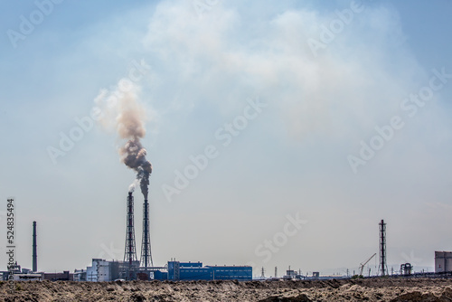 Working factory. Smoke from the factory chimney. Ecological pollution. Air emissions polluting the city. Industrial waste is hazardous to health. Large factory in smog, Production in operation.