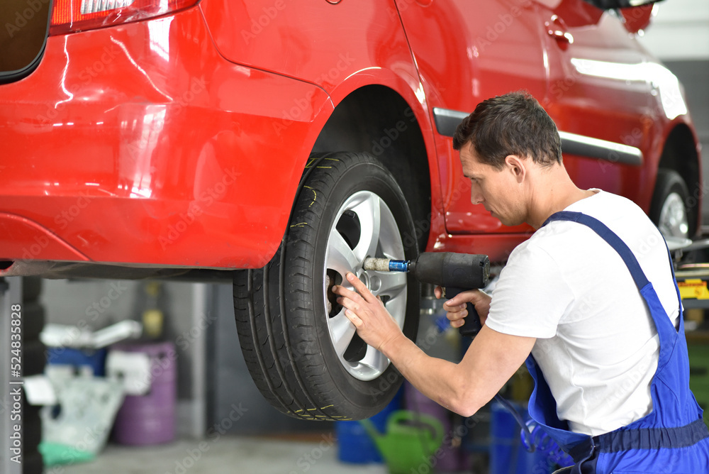 tyre change in a car repair shop worker assembles rims on the vehicle