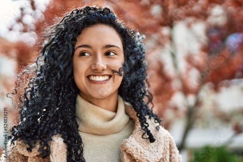 Young hispanic woman smiling confident at street