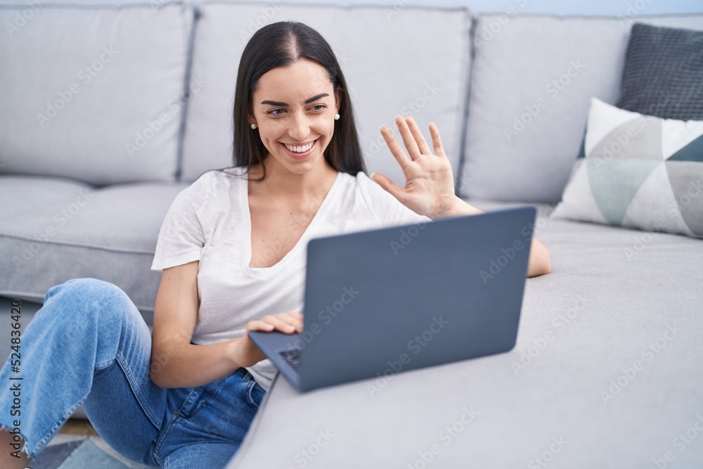Young brunette woman using laptop at home looking positive and happy standing and smiling with a confident smile showing teeth Young brunette woman using laptop at home looking positive and happy standing and smiling with a confident smile showing teeth