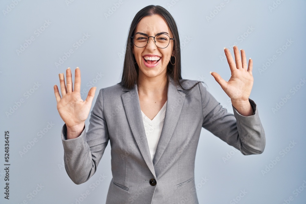 Hispanic business woman wearing glasses showing and pointing up with fingers number ten while smiling confident and happy. Hispanic business woman wearing glasses showing and pointing up with fingers number ten while smiling confident and happy.