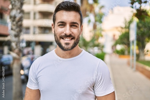 Young hispanic man smiling confident walking at street