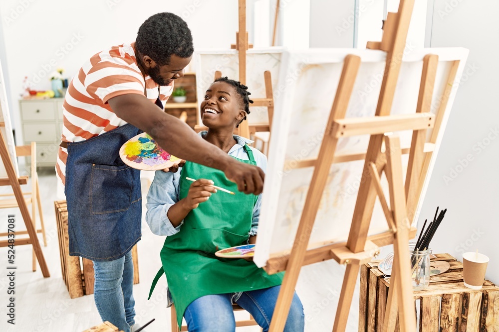 African american painter couple smiling happy painting at art studio. African american painter couple smiling happy painting at art studio.