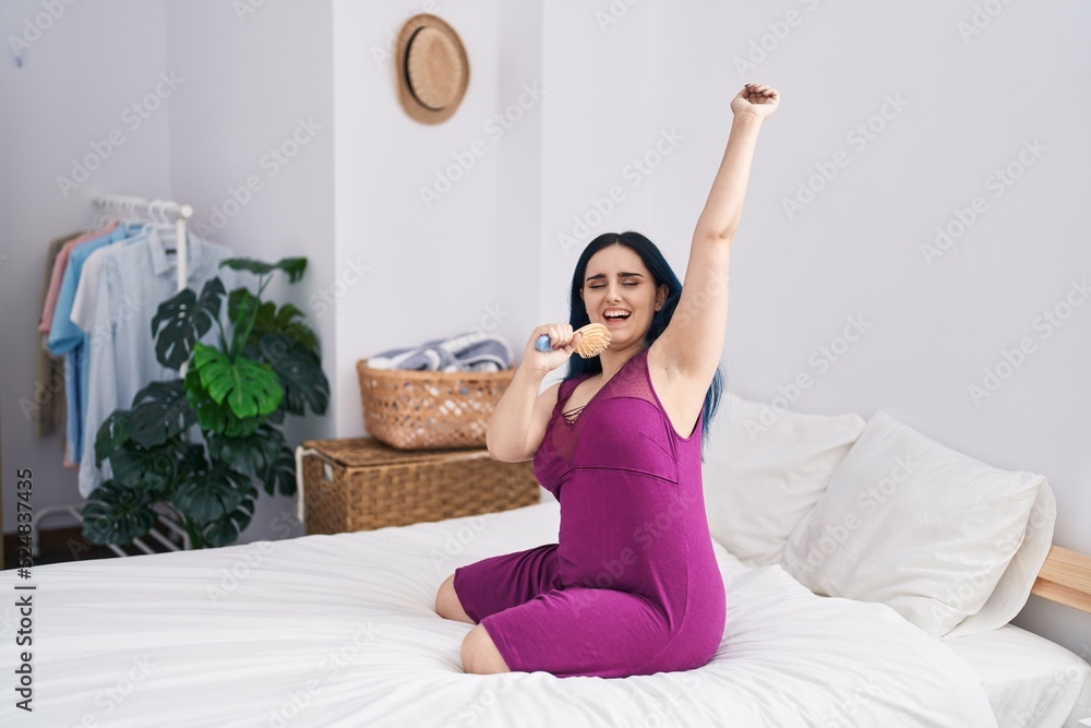 Young caucasian woman singing song using brush as a microphone at bedroom Young caucasian woman singing song using brush as a microphone at bedroom
