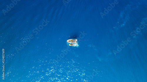 Seascape with boats. Aerial view of floating boat on blue sea at sunny day. Nautical vessel. Top view from drone on the azure sea. Travel and vacation image