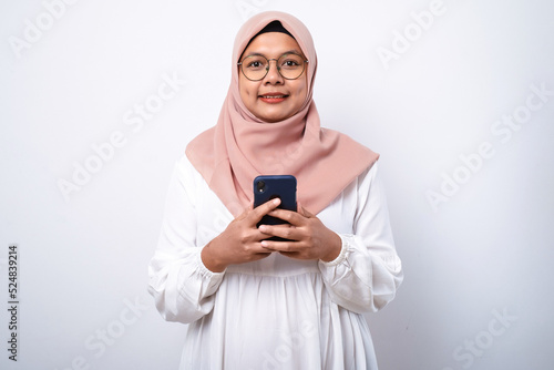 Young asian muslim woman smiling using mobile phone © Reza