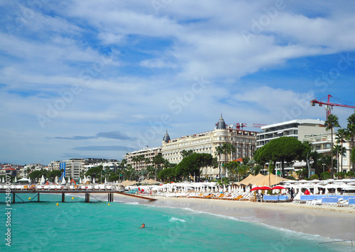 Cannes, Cote d'Azur, France - October 2019: People sunbathing on a hot summer day on the beach along the Promenade de la Croisette is in Cannes, Cote d'Azur, France